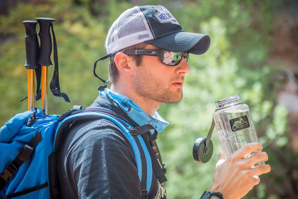 A hiker using a Tritan water bottle from Helikon-Tex
